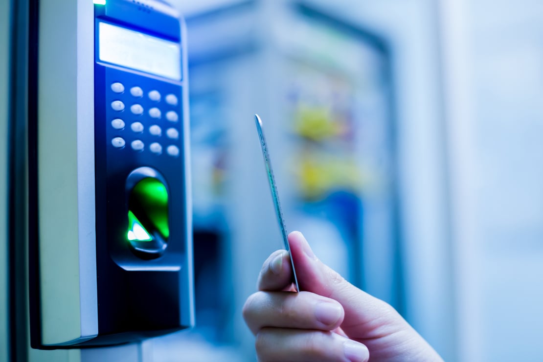 Door access control. Staff holding a key card to lock and unlock door at control room or data center.